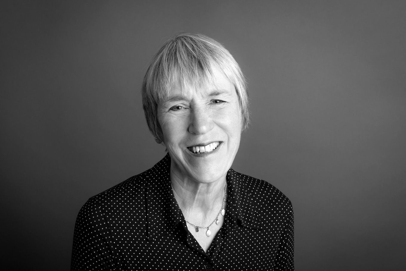 A portrait of a woman taken in a studio set up with backdrop and lighting equipment